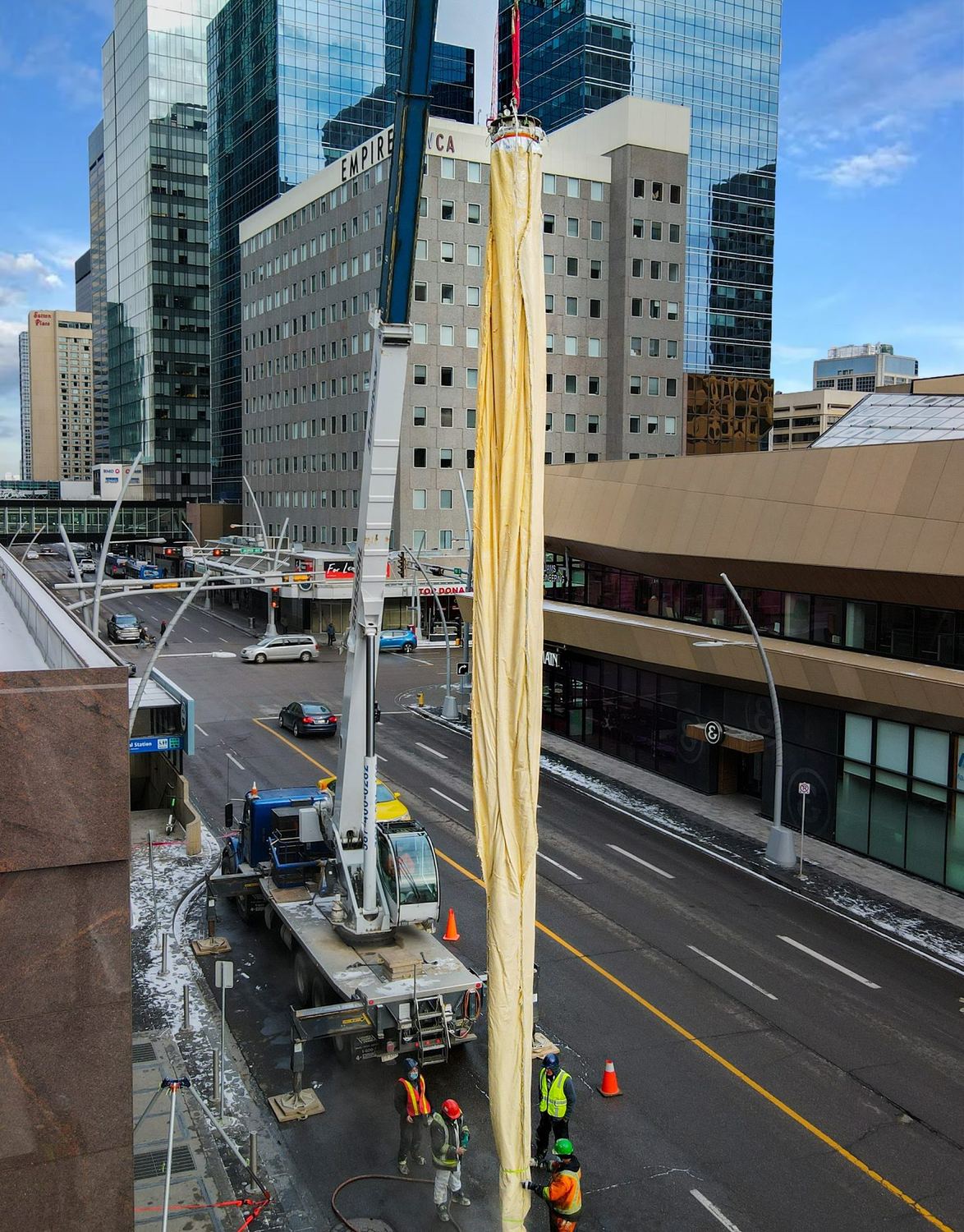 A Triplex Liner suspended from a crane in downtown Edmonton